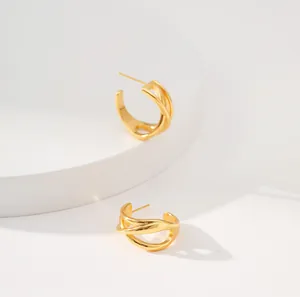 Detail der mehrlagig gekreuzten hohlen C-Ohrringe mit poliertem 18K Gold-Finish