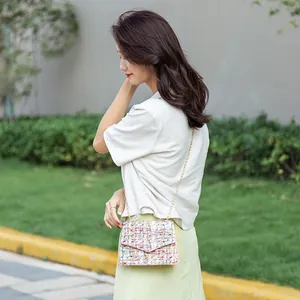 Colorful tweed small crossbody bag with gold chain strap shown on a female model