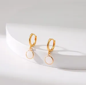 Detail of French vintage gold hoop earrings with white round stone pendants