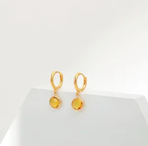 Detail of vintage French gold earrings with faceted yellow zircon and polished finish