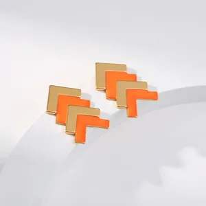 Makroaufnahme von 18K vergoldeten V-Ohrsteckern mit orangefarbenem Emaille-Detail