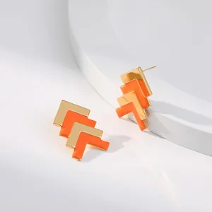 Makro-Detail von geometrischen Messingohrringen mit 18K Goldbeschichtung und Emaille