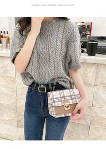 Close-up of color contrast check pattern bag with gold chain strap on a model