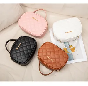 Vue de dessus de quatre sacs caméras matelassés en similicuir rose, blanc, noir et brun