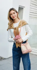 Sac seau tissé en cuir rose et paille beige avec cordon et bandoulière fine