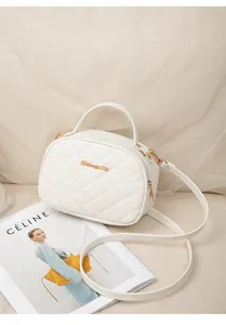 Détail du sac bandoulière blanc matelassé avec logo doré et poignée supérieure fixe