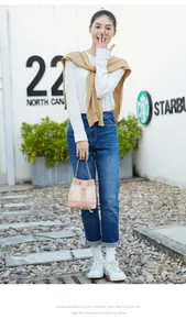 Détail du sac seau en cuir rose et paille tressée avec cordon et poignée mince