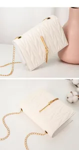 Detail of cream quilted bag with gold tassel pendant and elegant chain shoulder strap