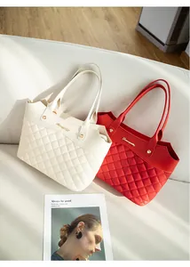 Détail du sac seau matelassé avec grandes coutures en losange et logo en métal doré