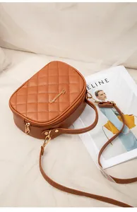 Détail du sac bandoulière marron matelassé avec logo doré et texture en cuir