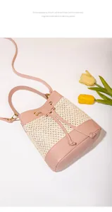 Détail du sac seau en paille tressée avec garniture en cuir rose et tulipes décoratives