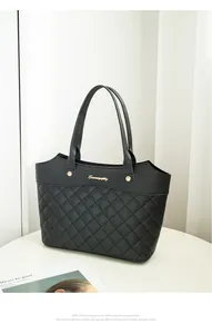 Détail du sac cabas noir avec surpiqûres en losanges et logo doré sur le dessus