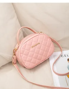 Détail du sac caméra matelassé rose clair avec logo doré et bandoulière à coutures ondulées