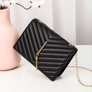 Elegant black quilted crossbody bag with gold chain strap and stylish fringe tassel