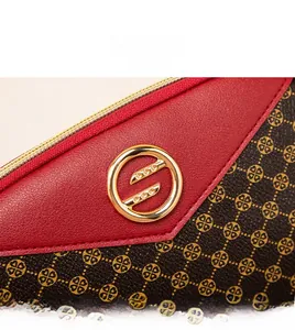 Détail macro du sac à main en cuir rouge avec fermoir doré et motif floral élégant