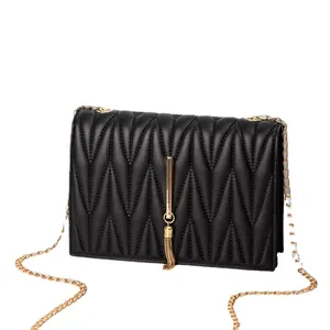 Elegant black quilted crossbody bag with golden V-shape stitching and tassel chain