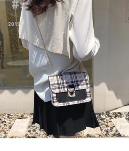 Close-up of checkered crossbody bag with sequin panel, metal lock and gold chain strap