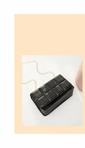 Close-up of black quilted small square bag featuring golden chain strap and leather texture