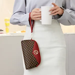 Pochette chic pour femme avec monogramme brun et cuir rouge contrasté au poignet