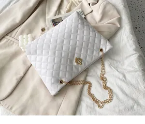 Detail der weißen gesteppten Beuteltasche mit Goldkette und Kronen-Perlenanhänger