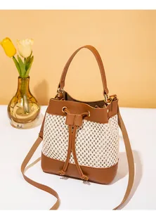 Détail du sac seau en cuir marron et tissu tissé avec cordon de serrage et finitions dorées
