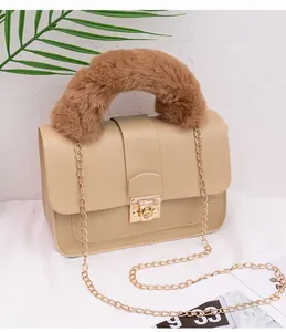 Detail of khaki square crossbody bag with brown faux fur handle and gold metal lock