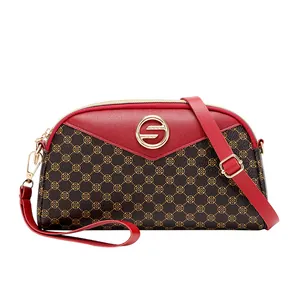 Sac bandoulière femme avec motif trèfle marron et panneaux en cuir rouge contrastés