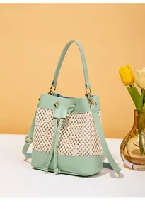 Détail du sac seau tissé vert menthe et beige avec cordon de serrage et tulipes