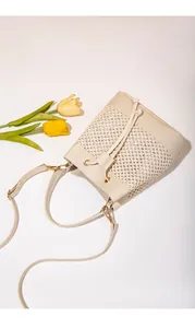 Vue de dessus du sac seau beige en paille tressée avec cordon et fleurs