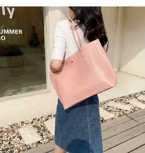 Pink crocodile pattern tote bag shown from side profile on a fashion model shoulder