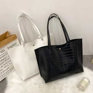 Crocodile pattern tote bags in black and white with slim shoulder straps and gold buckles