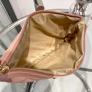 Pink quilted leather clutch bag with golden inner lining and metal zipper closure