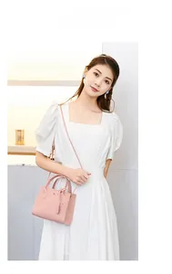 Detail of pink embossed crossbody bag featuring cute pattern and adjustable strap