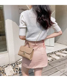 Close-up of a beige quilted crossbody bag with gold chain strap and metal lock
