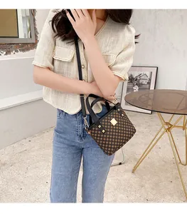 Mini handbag with retro geometric patterns and black leather handles shown on a model