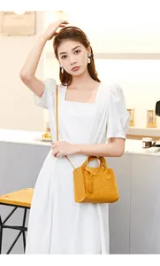 Detail of yellow crossbody bag featuring embossed cartoon patterns and leather texture