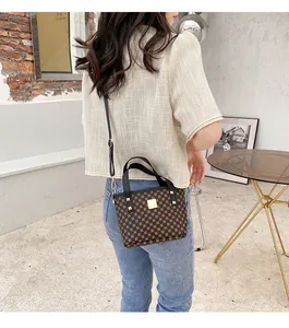 Brown monogram bucket bag styled with a white tweed jacket and jeans for a casual look