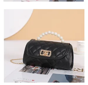 Détail du sac cylindre en cuir matelassé noir avec poignée en perles et fermoir doré