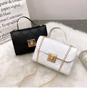 Detail of quilted small crossbody bag featuring gold twist lock and chain strap