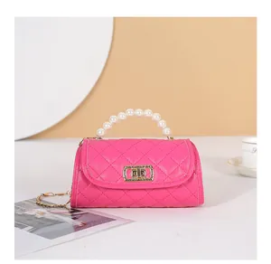 Vue détaillée du sac cylindre rouge rose avec poignée en perles et fermoir doré rotatif