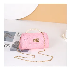 Détails du sac cylindre matelassé rose avec poignée en perles et chaîne dorée