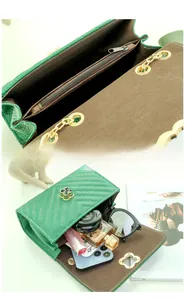 Detail of emerald green quilted crossbody bag with gold clover lock and organized interior