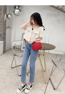 Close-up of red quilted crossbody camera bag with elegant gold chain strap detail