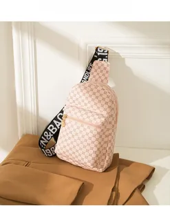 Close-up of pink crossbody bag with circular pattern and wide woven shoulder strap