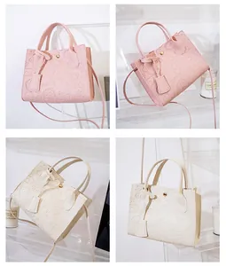 Detail of embossed pattern on pink and beige PU leather handbags with heart motifs