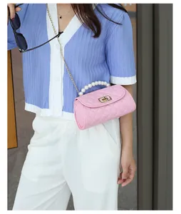 Détail du mini sac matelassé rose avec poignée en perles et fermoir doré rotatif