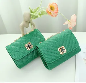Detail view of green quilted leather chain bags with gold flower buckles and V-stitch pattern