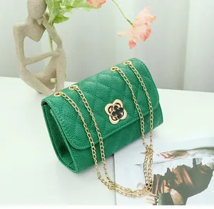 Detail of green pebble leather bag featuring diamond quilting and gold flower clasp