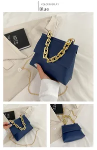 Detail der blauen Lederhandtasche mit markantem goldfarbenem Kettenkanten und Schulterriemen