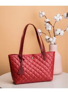 Détail du sac cabas rouge matelassé en similicuir avec bouton pression doré